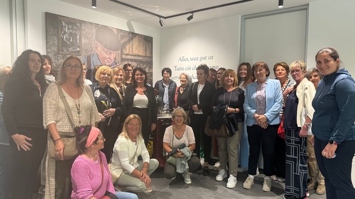 Frauen entdecken Traditionsbetriebe Gruppe von Frauen steht in einem Raum mit einem großen Bild und Text an der Wand