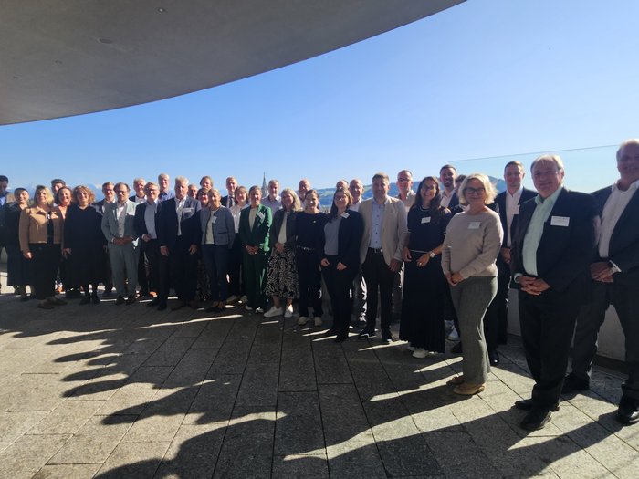 Attraktivität und Zukunft der Berufsbildung in Europa diskutiert Große Gruppe von Menschen, die vor Glasgeländer und klarem Himmel stehen