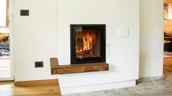 Kaminbrände vorbeugen Moderner Kamin mit brennendem Feuer in einem hellen Raum