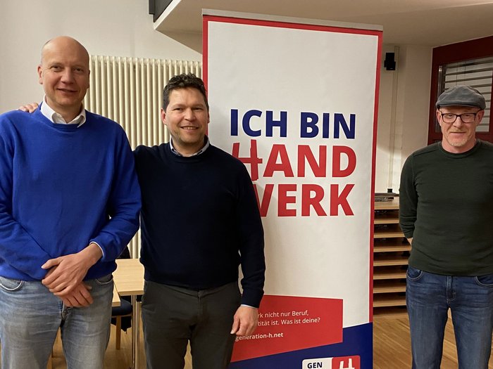 Handwerk mit Perspektive: lvh-Ortsversammlung in St. Martin in Thurn Drei Männer stehen neben einem Plakat mit dem Text Ich bin Handwerk