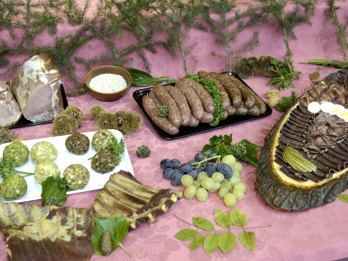 © lvh.apa Verschiedene regionale Fleischprodukte und Beilagen auf einem rosa Tisch