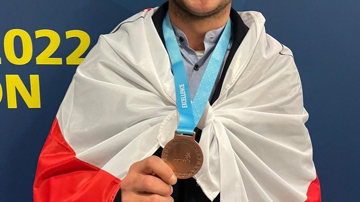 WorldSkills Competition 2022 Special Edition: Südtiroler holt Medallion for Excellence Junger Mann mit Medaille und polnischer Flagge um die Schultern