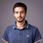 Das lvh-Team Porträt eines jungen Mannes mit dunklem Haar und blauem Poloshirt vor grauem Hintergrund