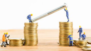 News Miniaturarbeiter montieren große Schraube auf Stapel goldener Münzen