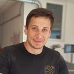 Bozen Land Porträt eines lächelnden Mannes mit kurzem braunem Haar in einem schwarzen T-Shirt