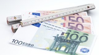 © Rallef/iStock Euroscheine und ein Maßstab auf weißem Hintergrund