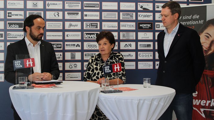 Landesrat Philipp Achammer, Unternehmerin Johanna Falser und lvh-Präsident Martin Haller © lvh.apa Drei Personen bei einer Podiumsdiskussion vor Sponsorenwand mit Generation H-Logo