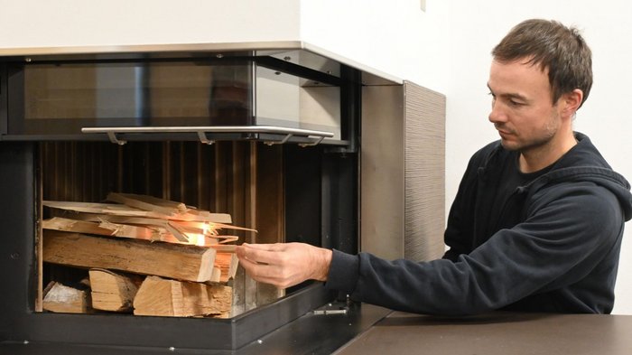„Il caos del traffico è preprogrammato“ Un uomo mette legna da ardere in una stufa a camino