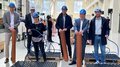 Einen Tag auf der Baustelle erleben Sechs Personen mit Schutzhelmen bei Vorführung von Bau- oder Installationsmaterial in Halle