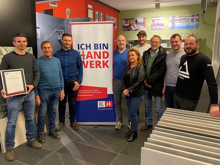 Handwerk: Fördergelder abholen Gruppe von neun Personen vor Banner ich bin handwerk in einem Innenraum