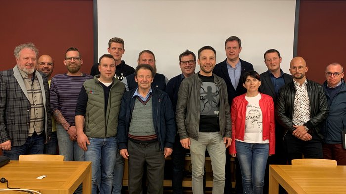 lvh: Junge Führung im Bezirk Klausen Gruppenfoto mit 14 Personen vor weißer Leinwand in einem Konferenzraum