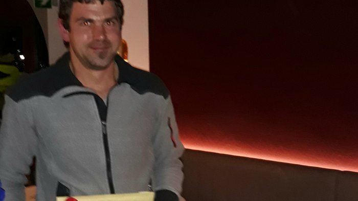 Dankesessen der Zimmerer Mann hält Geschenk mit roter Schleife in einem Restaurant