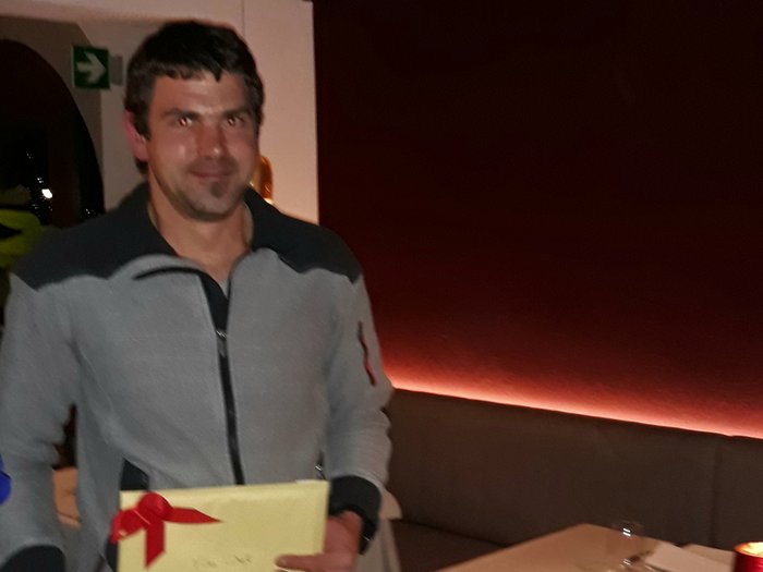 Dankesessen der Zimmerer Mann hält Geschenk mit roter Schleife in einem Restaurant