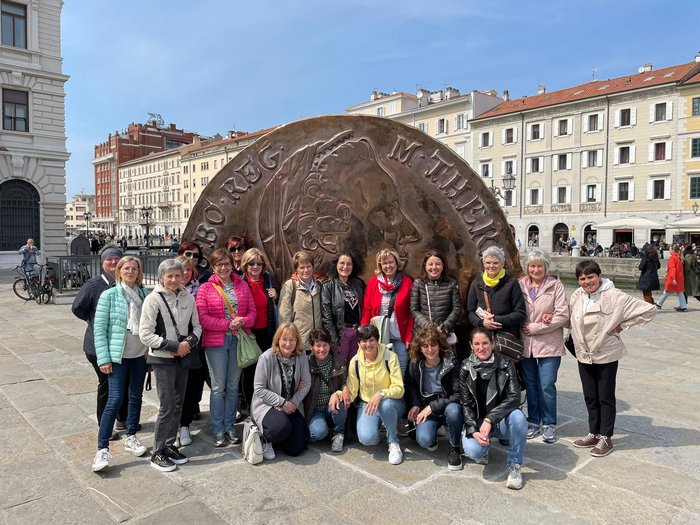 Triest, Miramare und Me(e)hr… Gruppe von Frauen vor großer Münzenskulptur auf einem Platz in der Stadt