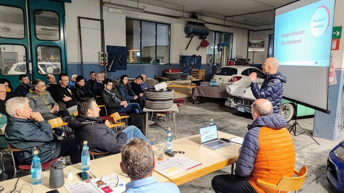 Attivi e orientati al futuro: l'artigianato di Ora Persona presenta a un pubblico in un'officina meccanica