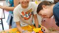 KidsAcademy 2025: Ein Sommer voller Handwerk und Kreativität Mädchen arrangiert bunte Blumen auf Tisch im Floristik-Workshop