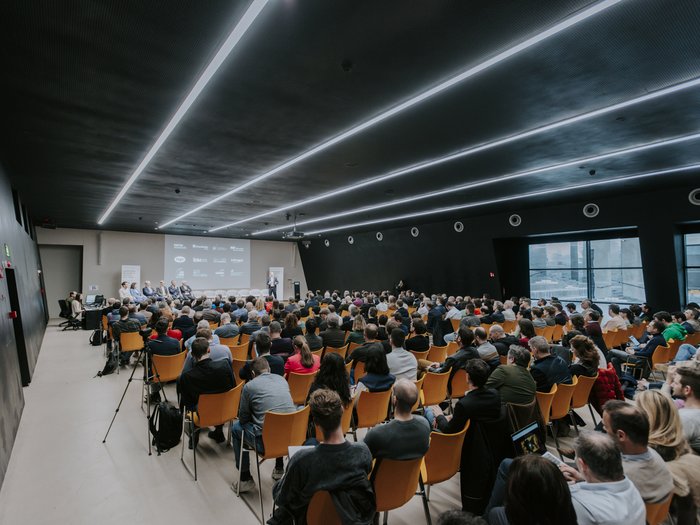 Anlaufstelle für Künstliche Intelligenz vorgestellt Großer Konferenzraum mit Publikum und Redner auf der Bühne