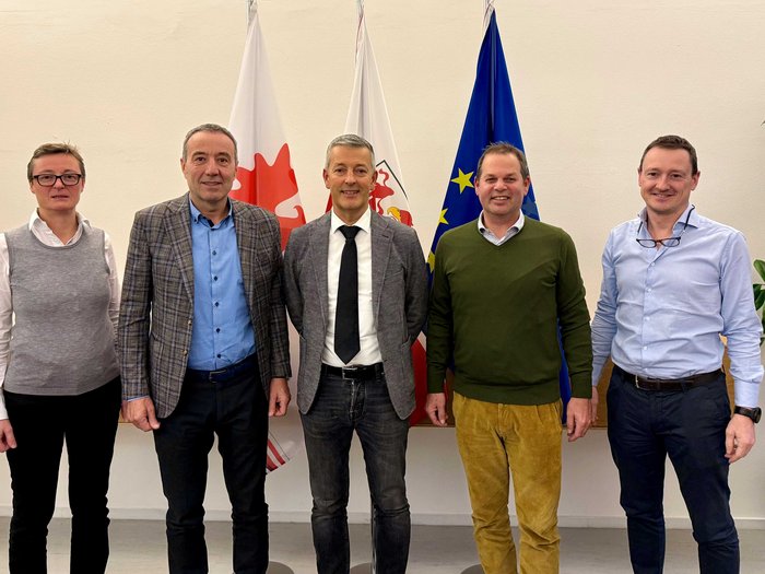 I vertici di lvh.apa incontrano i politici provinciali per discutere di pianificazione territoriale e gestione dei rifiuti Cinque persone posano davanti a bandiere in una foto di gruppo formale
