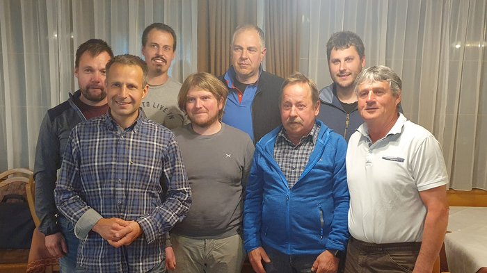 Mitgestaltung großgeschrieben Gruppe von neun Männern in einem Raum mit Vorhängen im Hintergrund