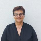 Frauen im Handwerk Frau mit kurzen braunen Haaren und Brille vor weißer Wand in schwarzem Oberteil