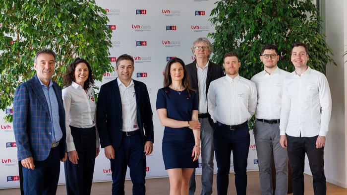 Dare forma al futuro con l'Intelligenza Artificiale: Le "Giornate dell'IA 2025” di Bolzano stabiliscono nuovi standard nel settore dell'artigianato Otto persone posano davanti a uno sfondo con logo lvhapa e Generation H