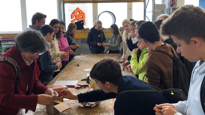 SkillsDay Gruppe von Jugendlichen bei praktischer Aktivität in Werkstatt mit Metallrohren und Werkzeugen