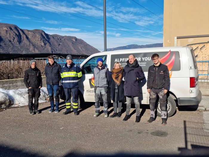 Aktivitäten der Hafner/innen im lvh Gruppe von sieben Personen posiert vor einem Firmenfahrzeug bei sonnigem Wetter