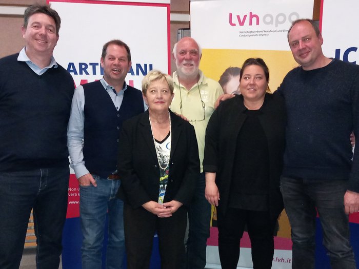 Starke Führung in Bozen Sechs Personen posieren vor Bannern bei einer Veranstaltung