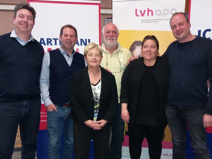 Forte leadership a Bolzano Sei persone posano davanti a banner durante un evento
