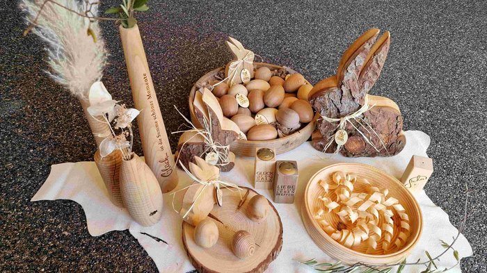 Ostern: Mehr als Osterbrot und Fochaz Ostereier und Hasen aus Holz mit dekorativen Vasen auf weißem Tuch