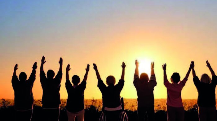 Invito al convegno: “Ce l’abbiamo fatta!” Inclusione nel mondo lavorativo Persone con le braccia alzate all'alba, una su sedia a rotelle