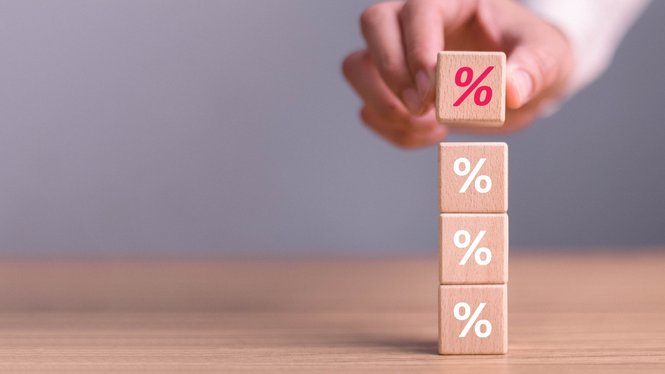 Home Mano che impila cubi di legno con simbolo percentuale su tavolo