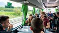 WorldSkills 2024 in Lyon am Start Junge Leute spielen Karten und unterhalten sich in einem Bus mit grünen Vorhängen