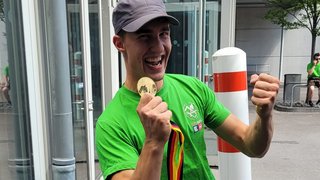 Foto 1 - Marcel Bolego © Südtiroler Zimmerer Junger Mann freut sich mit Medaille und grünem T-Shirt im Freien