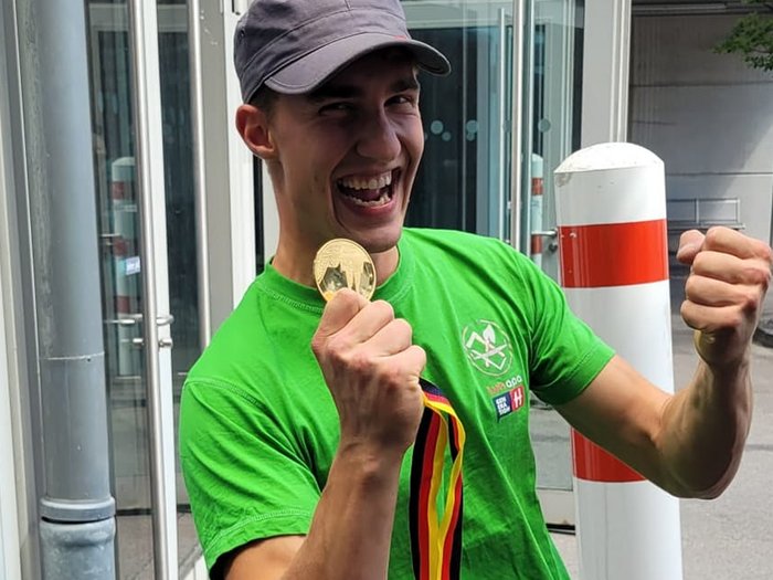 Carpentieri: Marcel Bolego è campione d’Europa! Giovane uomo felice con medaglia e maglietta verde all'aperto