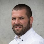 Oberpustertal Porträt eines Mannes mit kurzem Bart und weißem Hemd vor grauem Hintergrund