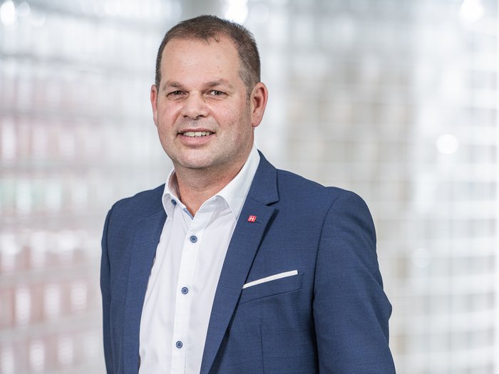 Sondertransport: Zusammenarbeit zwischen Unternehmen und der Stadtpolizei Bozen Porträt eines Mannes im blauen Anzug vor verschwommenem Hintergrund