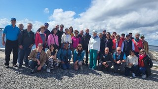 News Gruppe von Erwachsenen am Strand mit blauem Himmel und Wolken