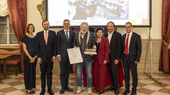 30 anni di WorldSkills South Tyrol, Italy: un percorso avvincente nella formazione professionale Gruppo di sette persone durante una premiazione con certificato e trofeo