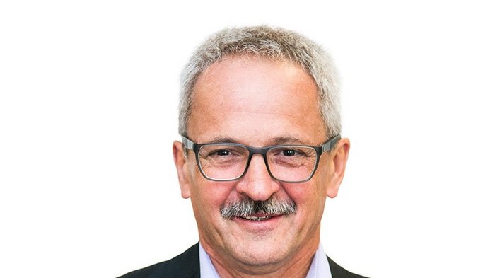 Tradition schafft Zukunft Porträt eines älteren Mannes mit Brille und grauen Haaren vor weißem Hintergrund