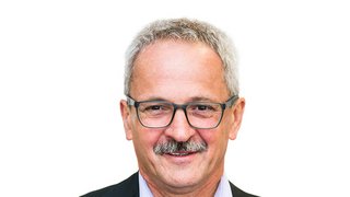 News Porträt eines älteren Mannes mit Brille und grauen Haaren vor weißem Hintergrund