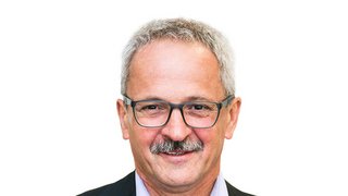 News Porträt eines älteren Mannes mit Brille und grauen Haaren vor weißem Hintergrund