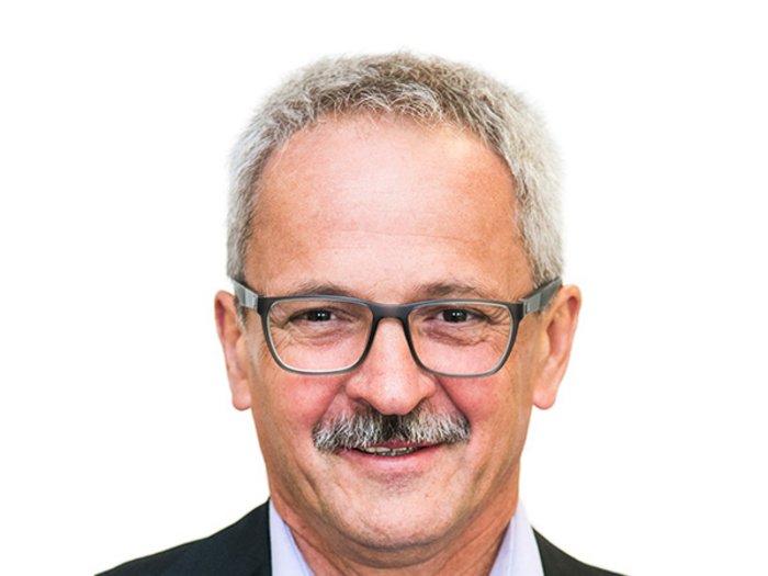 NOx Emissionen deutlich gesunken – trotz Lkw-Verkehr Porträt eines älteren Mannes mit Brille und grauen Haaren vor weißem Hintergrund