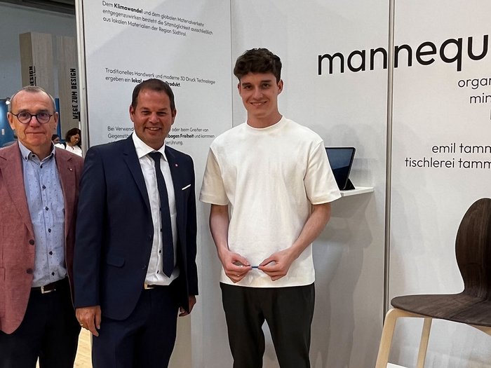 lvh-Direktor Thomas Pardeller, lvh-Vizepräsident Hannes Mussak und Emil Tammerle © lvh.apa Drei Männer vor Messestand mit modernem Stuhl aus Holz