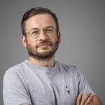 Das lvh-Team Porträt eines Mannes mit Brille und grauem T-Shirt vor grauem Hintergrund