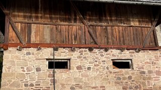 News Altes Haus mit Steinmauer und Holzdach in ländlicher Umgebung