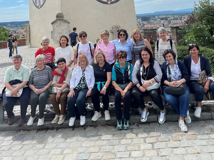 Tre giorni indimenticabili a Graz Gruppo di donne sedute davanti a un muro storico con la città sullo sfondo