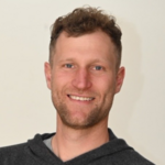 Bozen Land Porträt eines lächelnden Mannes mit lockigem Haar und dunklem Kapuzenpullover