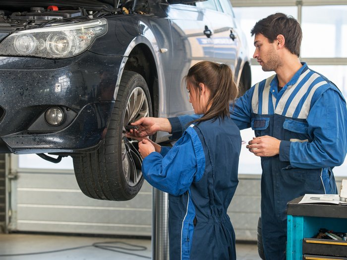 “Respirare quanto prima l’aria del lavoro” Due meccanici montano una ruota su un'auto in officina