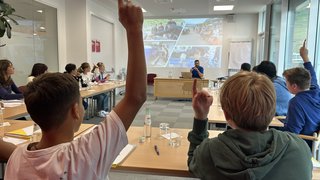 News Schüler heben die Hand in einem Klassenzimmer während einer Präsentation